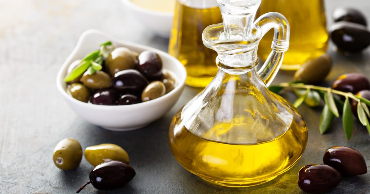 Ciotola di olive verdi e nere e bottiglia di olio 
